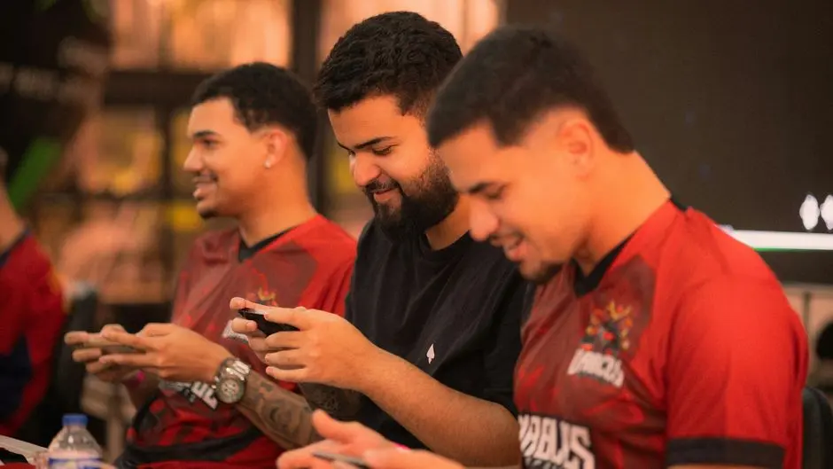 Pemain game mobile sedang fokus di layar ponsel saat turnamen lokal